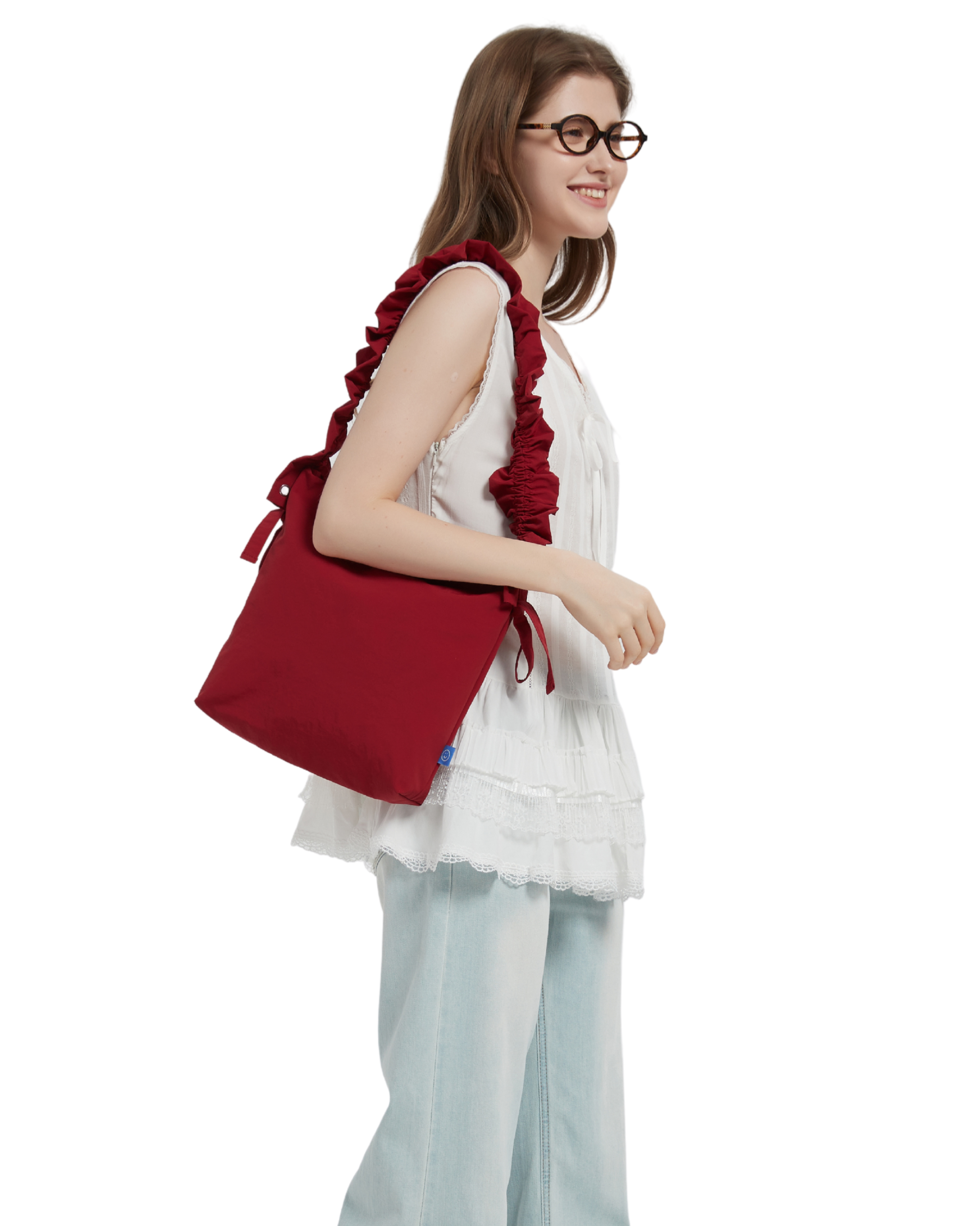 The petal bag in apple red as shown when it is shoulder carried on a model