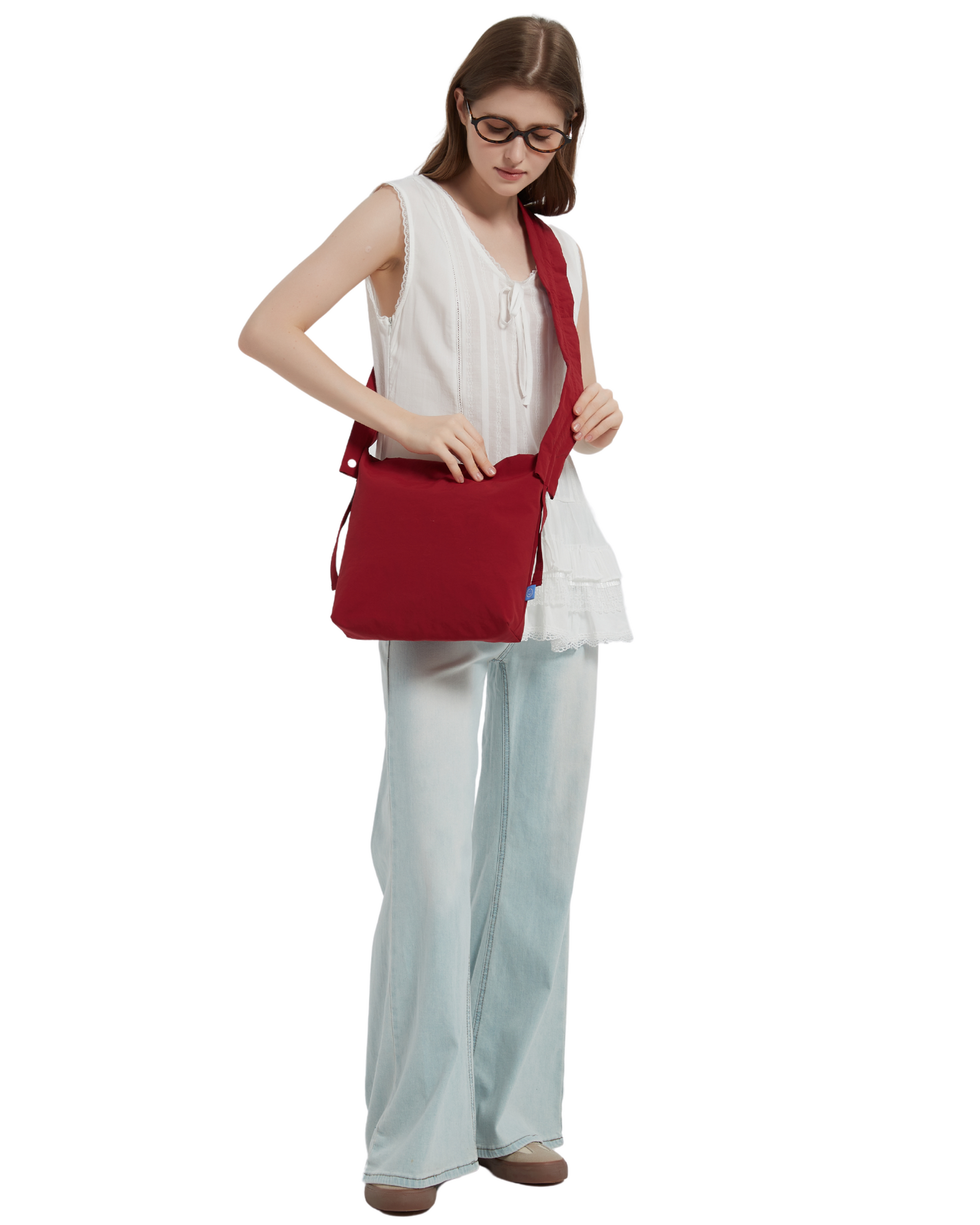 The petal bag in apple red as shown when it is slung across on a model