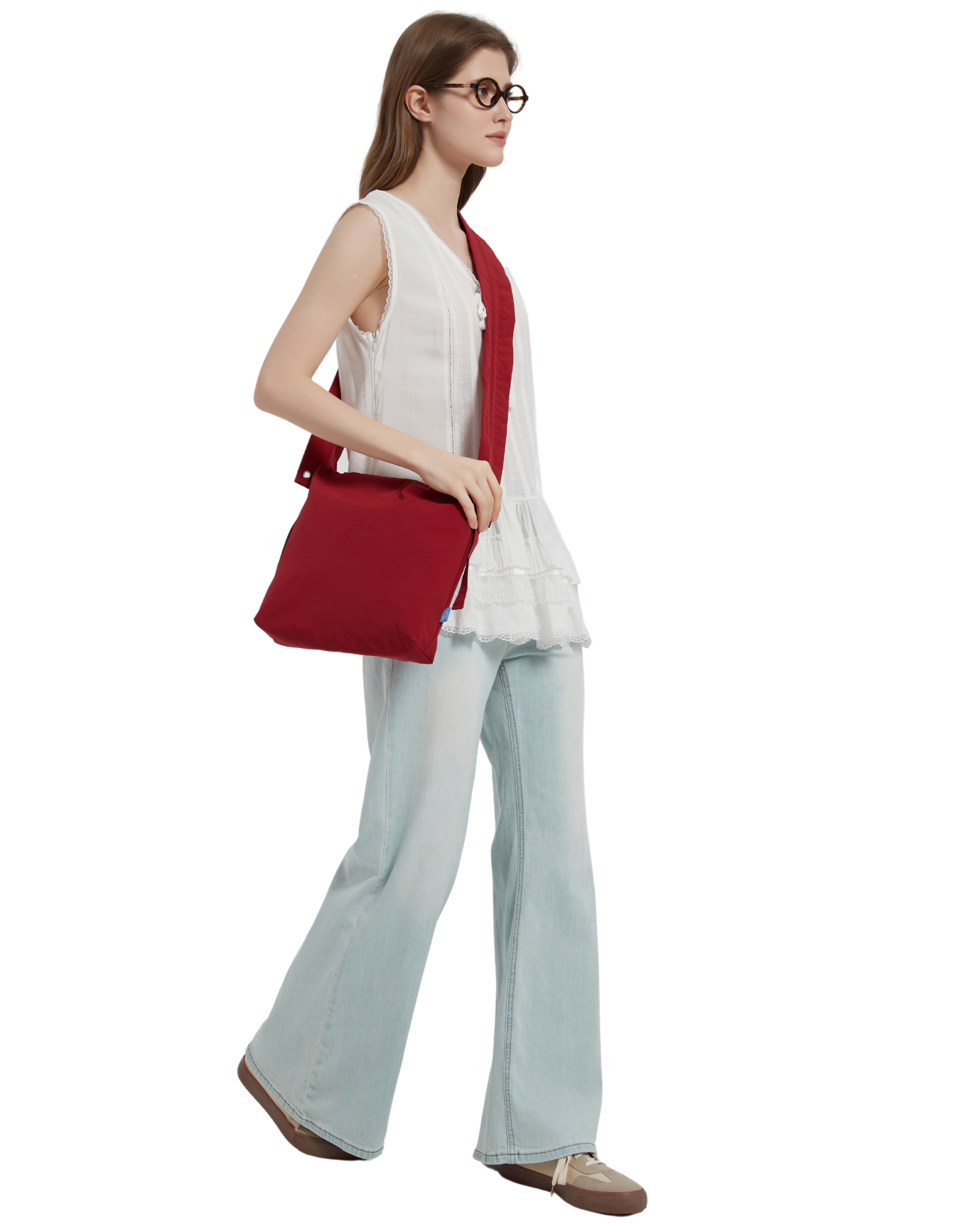 The petal bag in apple red as shown when it is slung across on a model