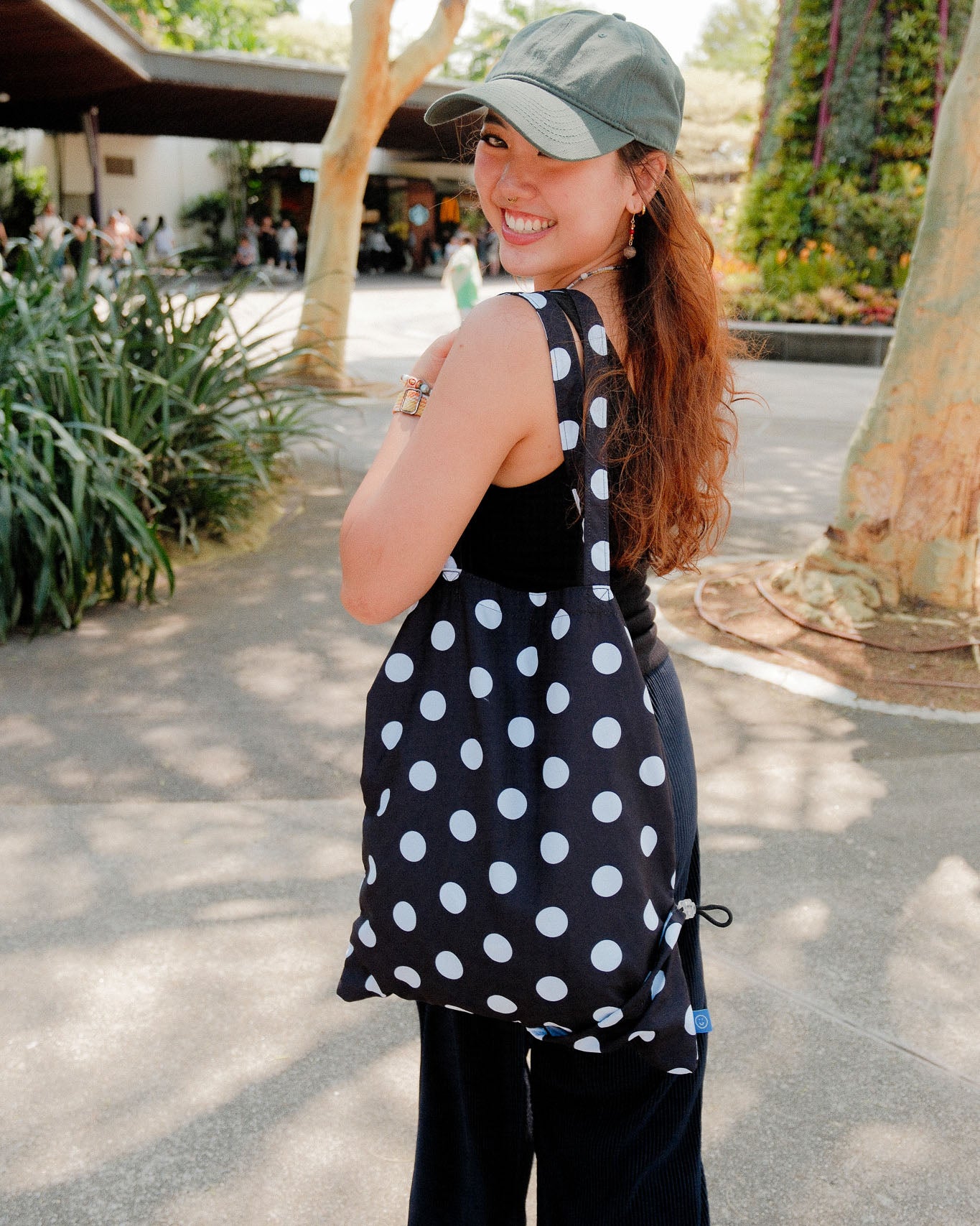 Woman with a black polka dot bag in an outdoor setting