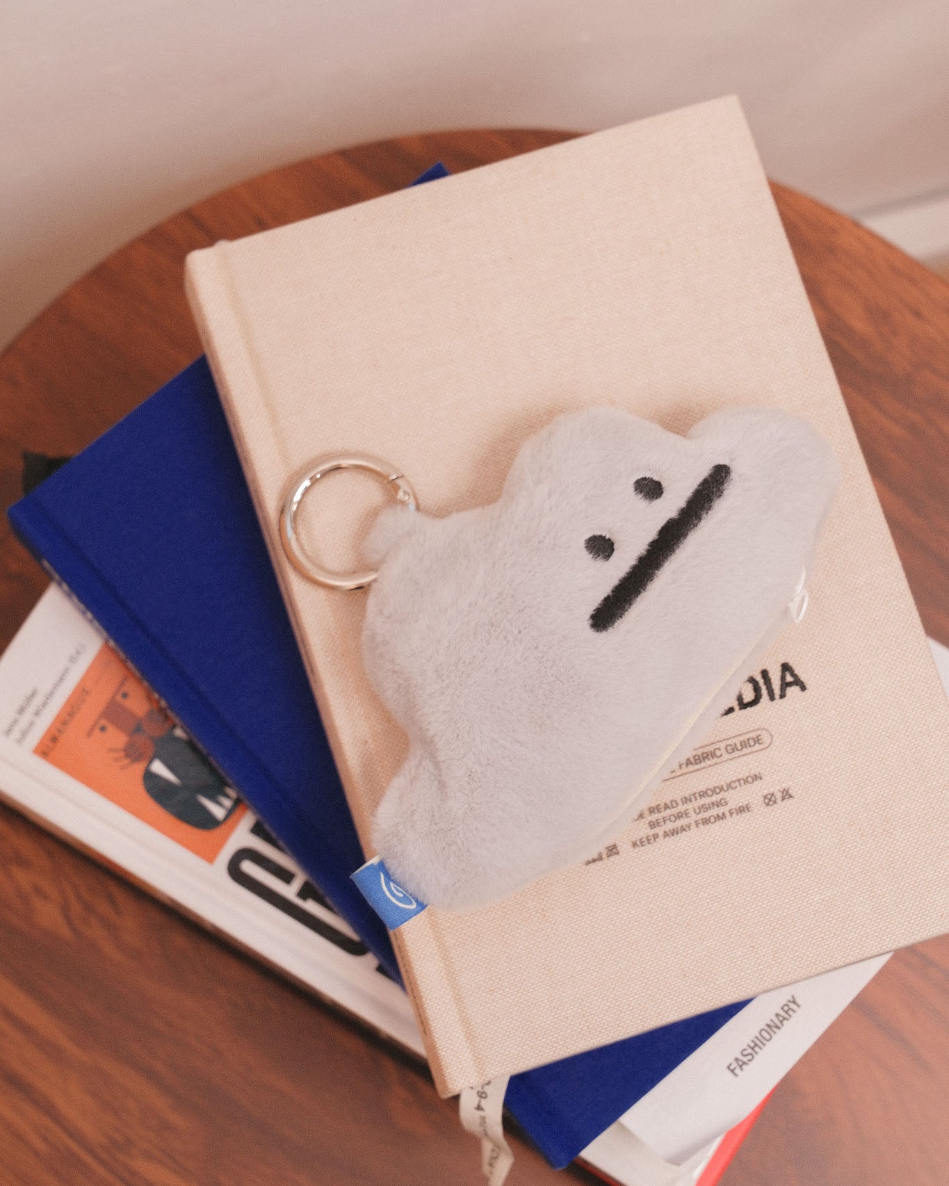grey cloud plushie on a stack of books